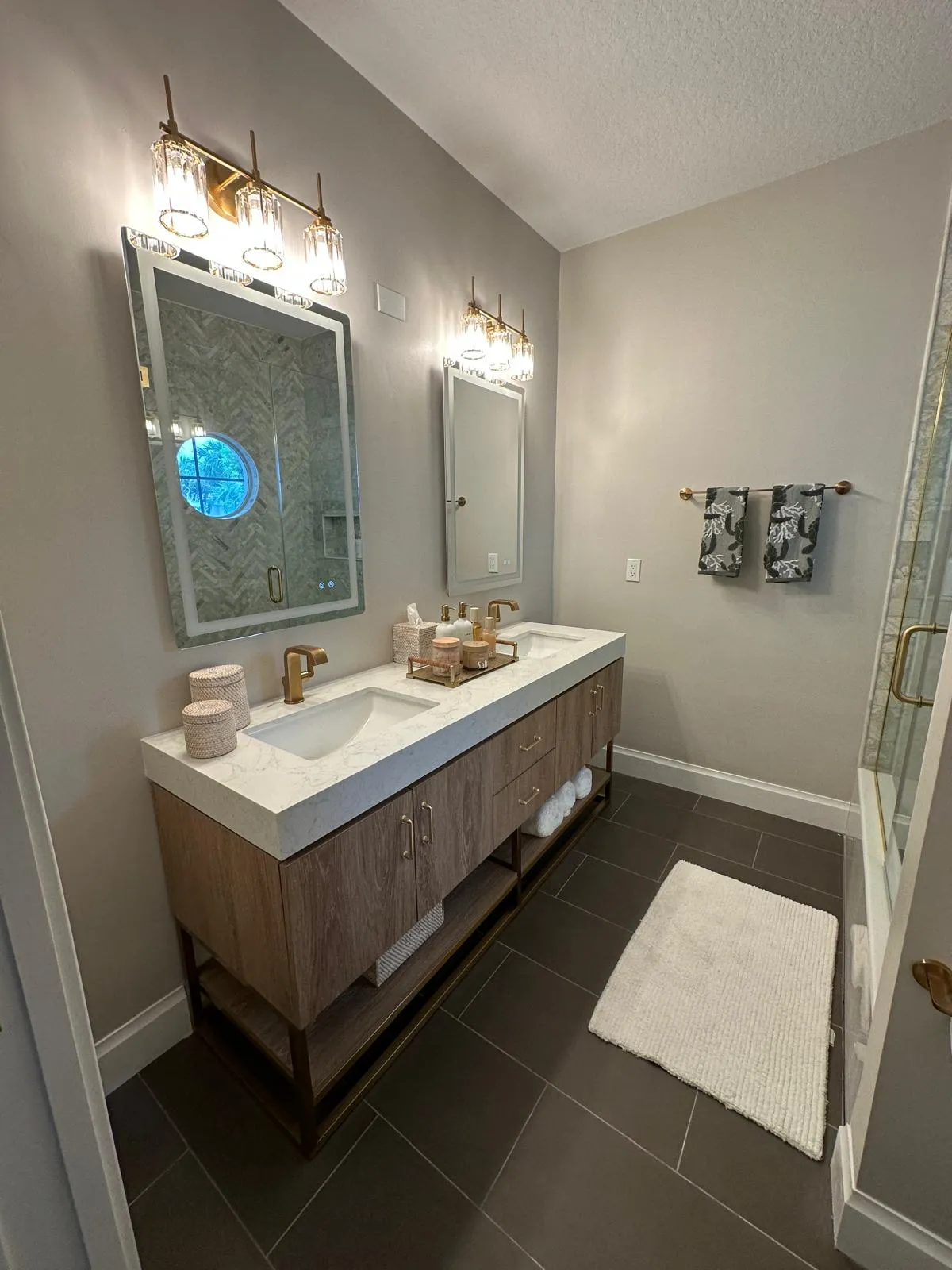 Double vanity with a lighted mirror and gold fixtures, bathroom remodeling in Port St Lucie, FL