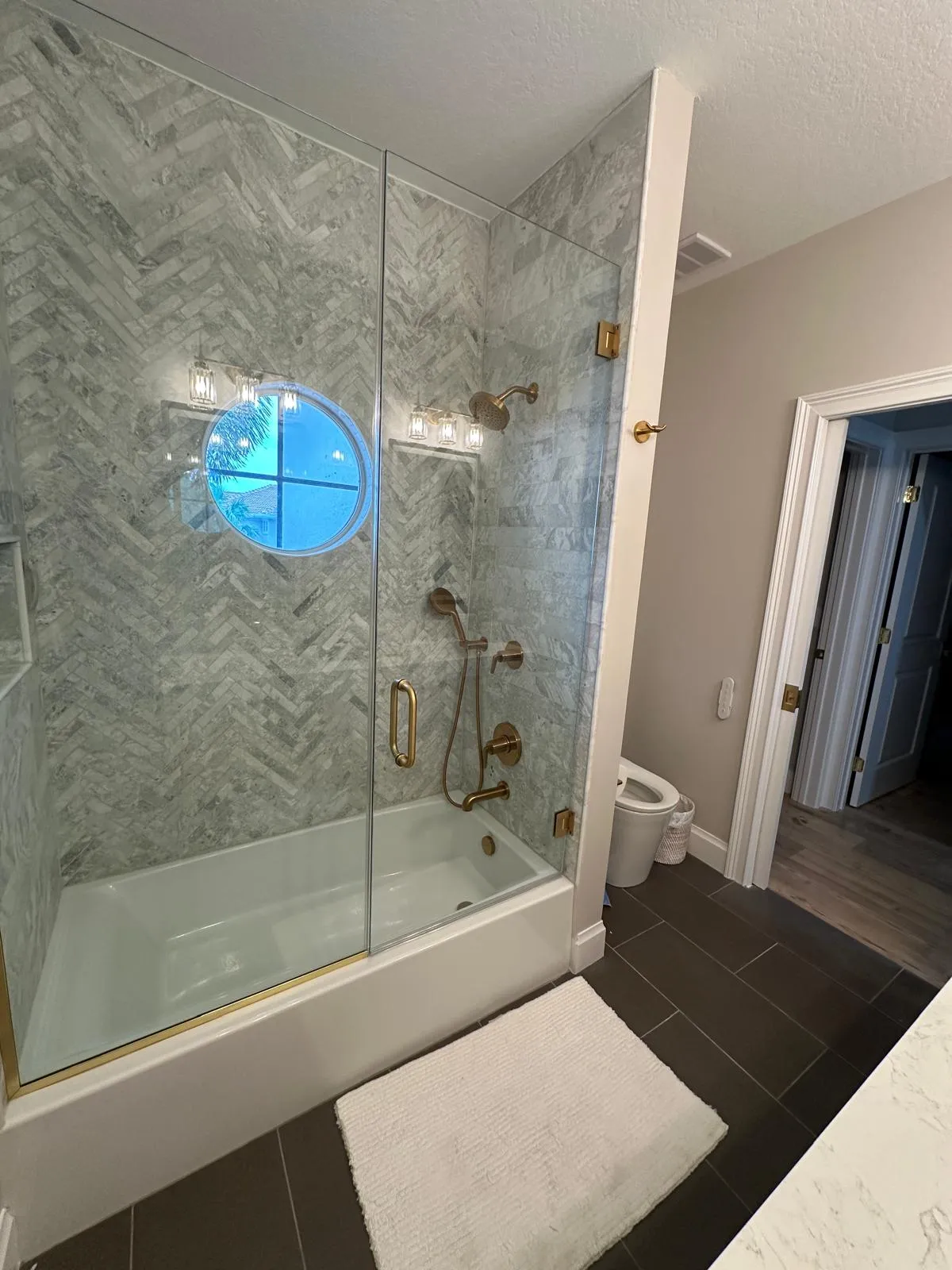 Shower and tub with a glass enclosure and gold trim, bathroom remodeling in Port St Lucie, FL